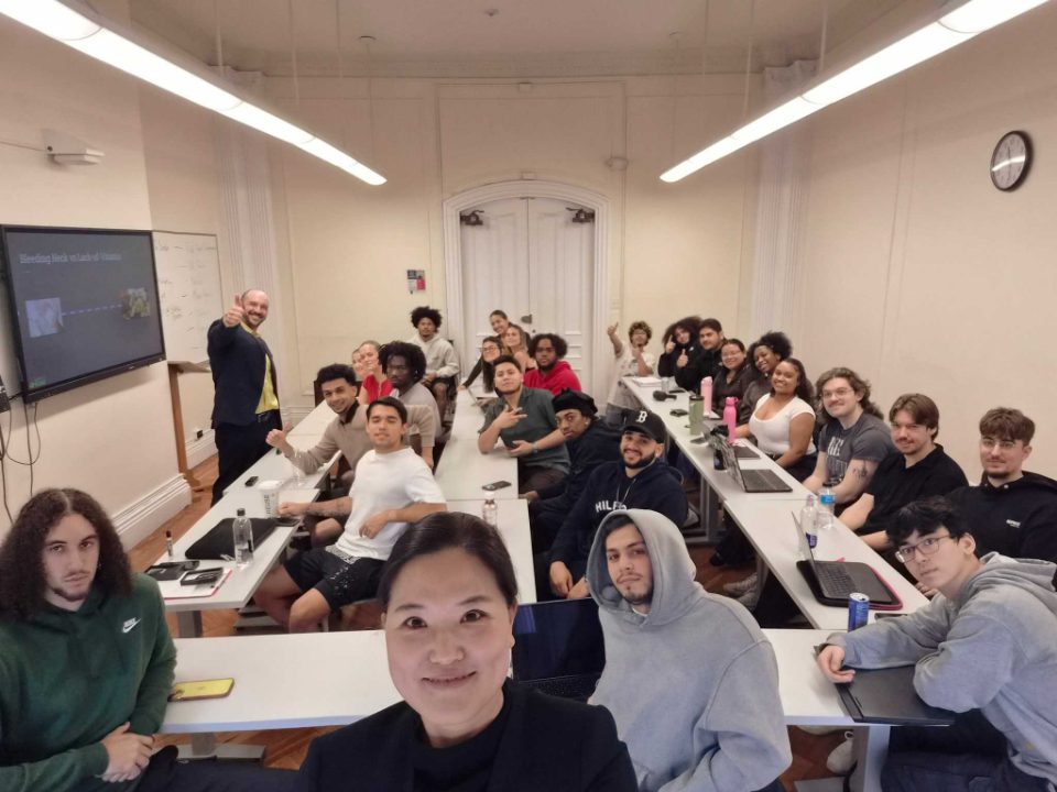 A college classroom of students at their desks, Dan Newman at the front of the room
